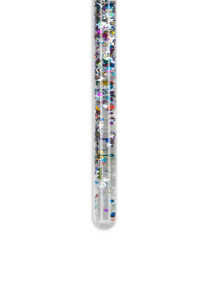 The Konges Sloejd Magical Glitter Wand - Star Glitter stands upright, showcasing clear liquid and sparkling, colorful star confetti inside its transparent tube, set against a plain white background.