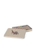 The Konges Sloejd Beeswax Crayons - Safari come in a beige tin box decorated with giraffe and elephant illustrations, filled with colorful, non-toxic crayons. The lid is shown resting next to the open box.