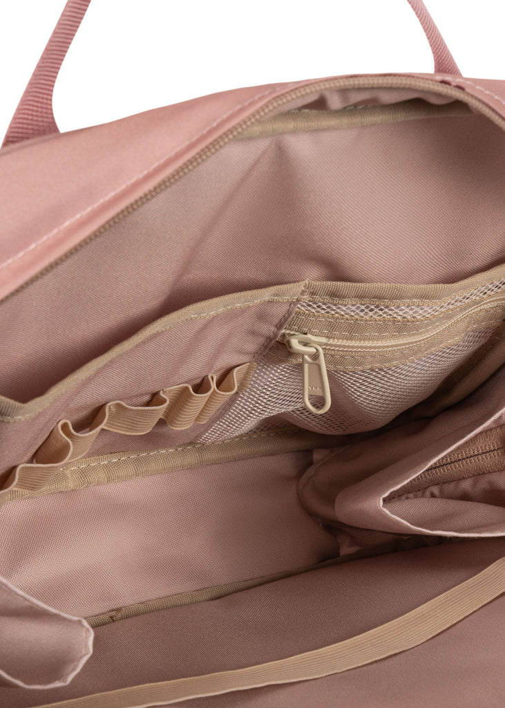 Close-up of the Konges Sloejd Holiday Essentials Bag - Cherry, showcasing its pink design with beige lining, zippered mesh pockets, elastic compartments, and organized sections—ideal as a kids travel bag for stationery and more.