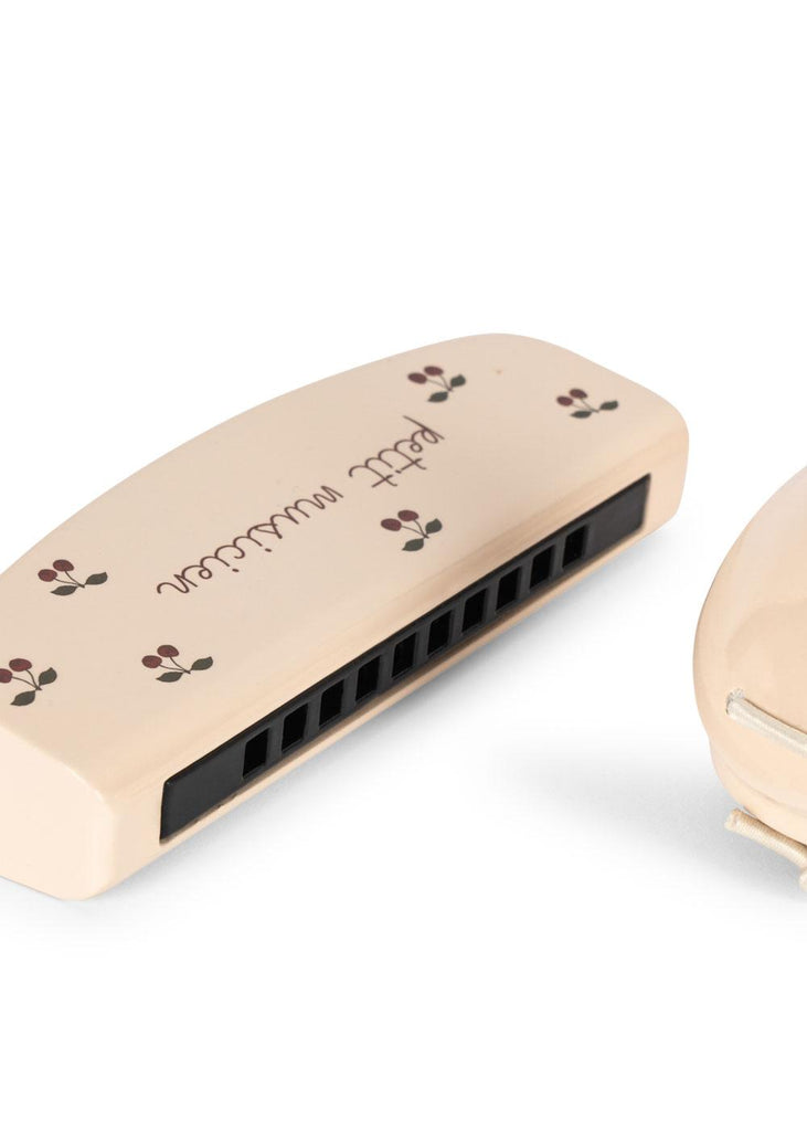 The Konges Sloejd Petit Music Set - Glossy Cherry features a cream-colored harmonica with brown floral designs and "petit musicien" on top, displayed against a white background.