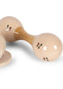 A Konges Sloejd Petit Music Set - Glossy Cherry maraca with a smooth finish and cherry design rests on a white surface, with part of another matching wooden instrument visible on the left.