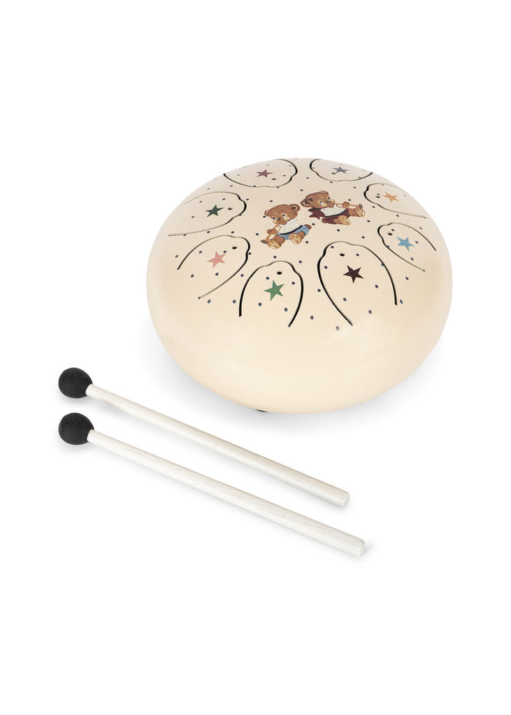 The Konges Sloejd Marly Steel Drum is a cream-colored steel tongue drum that comes with two black-tipped mallets. It features star patterns and charming illustrations of two children in the center, making it a delightful choice for beginners interested in musical play.