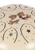 Close-up of the Konges Sloejd Marly Steel Drum in beige, featuring two adorable cartoon bears—one with a trumpet and the other with a drum—surrounded by stars and dotted patterns; an ideal choice for beginners eager to explore musical play.