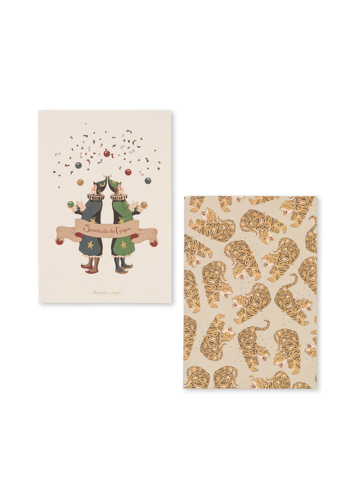 Two illustrated cards inspired by the “Konges Sloejd Creative Art Caddy - Tiger”: one features two playful cats in party hats beneath confetti and a cheerful banner—perfect for sparking creativity in any artist’s toolkit; the other showcases a lively pattern of orange tigers on a beige backdrop, making these cards an ideal addition to kids’ art supplies or a fun complement to a coloring set.