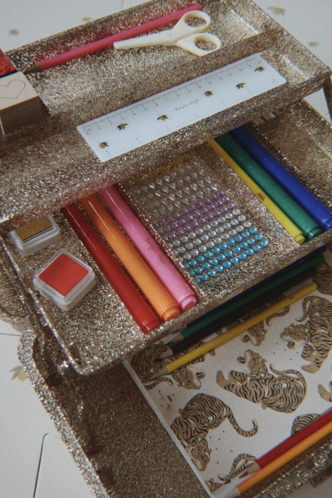 The Konges Sloejd Creative Art Caddy - Tiger is a glittery, three-tier organizer thoughtfully designed to hold pens, a ruler, markers, scissors, stamps, colored pencils, adhesive gems, and a notebook with a tiger print cover—making it the perfect art supply set for kids.