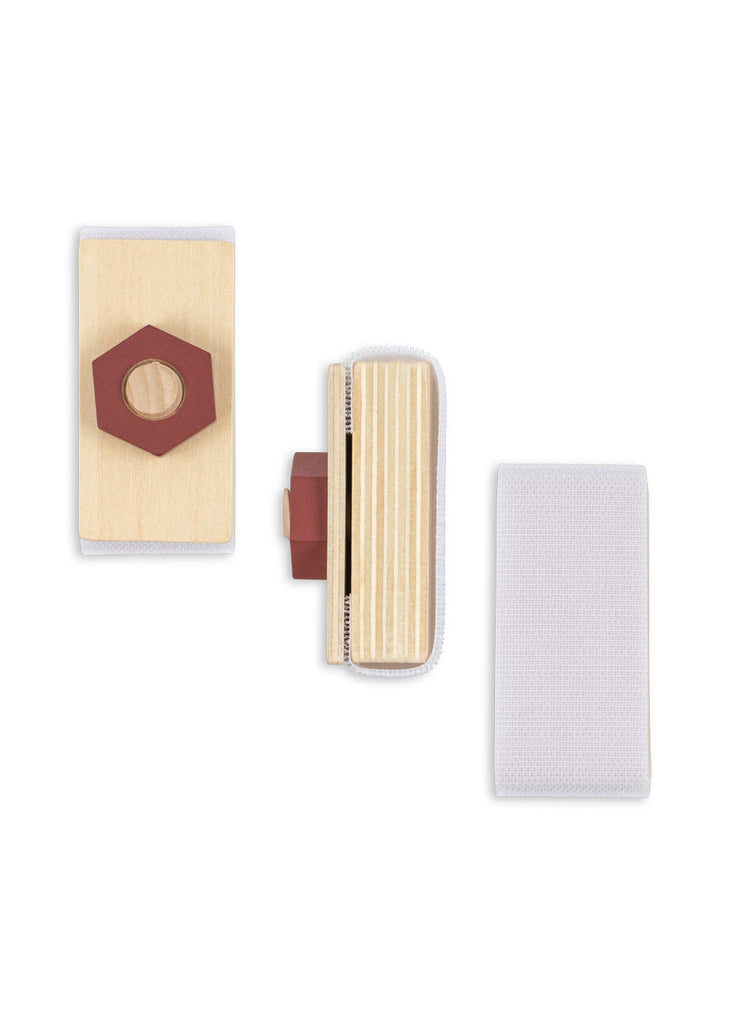 Three rectangular wooden blocks from the Konges Sloejd Tool Bench, each featuring Velcro strips and resembling pieces from a children’s workbench set. One block has a red hexagonal piece attached. The items are displayed from three different angles on a white background.