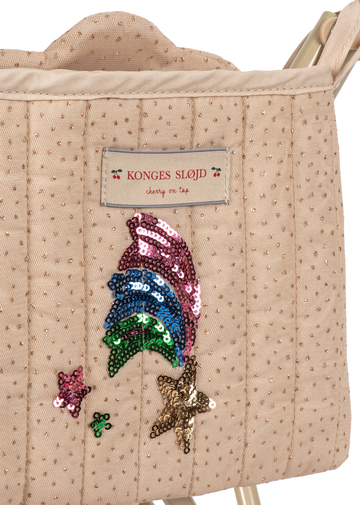 The Konges Sloejd Tulle Doll Stroller - Rainbow Star features a beige quilted fabric adorned with gold dots, a Konges Sløjd label, and colorful sequin designs of stars and rainbow-like shapes, making it a delightful accessory for any doll stroller collection.
