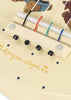 Close-up of the Konges Sloejd Wooden Ukulele - Teddy Bear, showcasing its cream-colored wooden bridge with vibrant colored strings, small black knobs, blue dots, and charming bear illustrations. This delightful kids’ musical instrument features “Konges Sløjd” elegantly written in gold cursive.