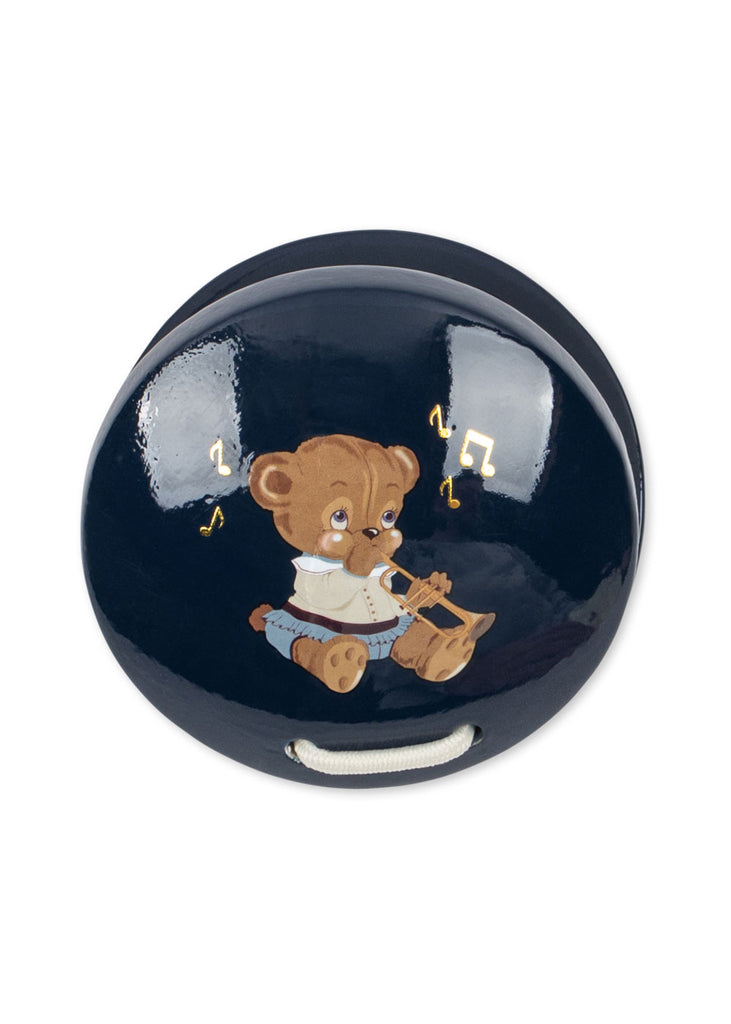 The Konges Sloejd Music Set - Teddy Bear features a dark blue oval design with a brown teddy bear illustration playing a violin, musical notes surrounding its head, and a white pull cord at the base—perfect for inspiring little ones’ love of music and complementing any kids instrument set.