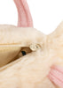 Close-up of the Konges Sloejd Puppy Bag - Off White, a cream-colored fluffy kids bag with pink handle and ears, open zipper showing beige lining and part of a printed eye inside.