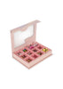 The Konges Sloejd ABC Jewelry Set is a pink bead box with a transparent lid, featuring twelve compartments filled with colorful, assorted beads shaped like animals and flowers. The open box displays the jewelry pieces inside.