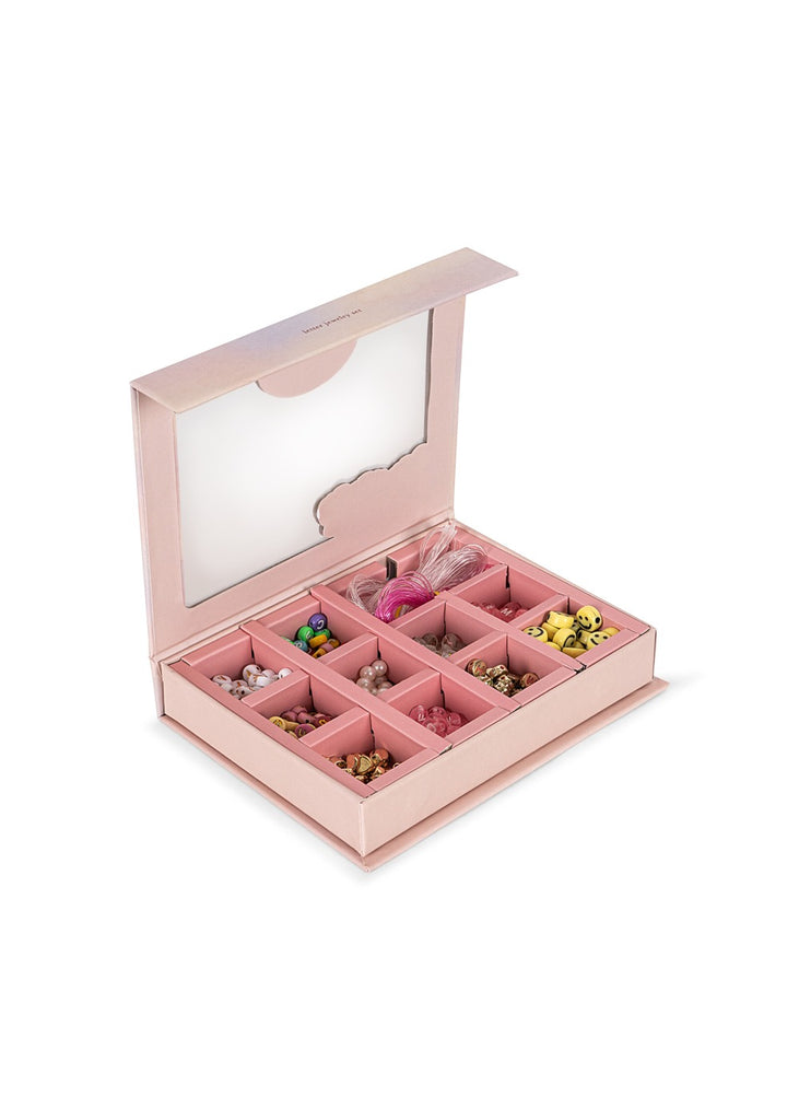 The Konges Sloejd ABC Jewelry Set is a pink bead box with a transparent lid, featuring twelve compartments filled with colorful, assorted beads shaped like animals and flowers. The open box displays the jewelry pieces inside.