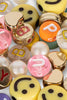 A close-up of the Konges Sloejd ABC Jewelry Set showcases smiley beads, gold accents, and letter pearls in pink, white, yellow, and orange—perfect for jewellery making.
