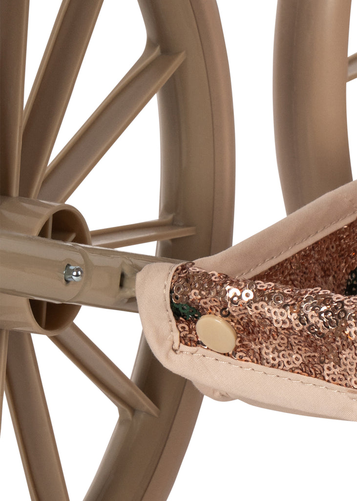 Close-up of a Konges Sloejd Mini Doll Pram - Sparkly Cherry Sequin, showing a vintage wheel and a section of fabric covered in bronze sequins.