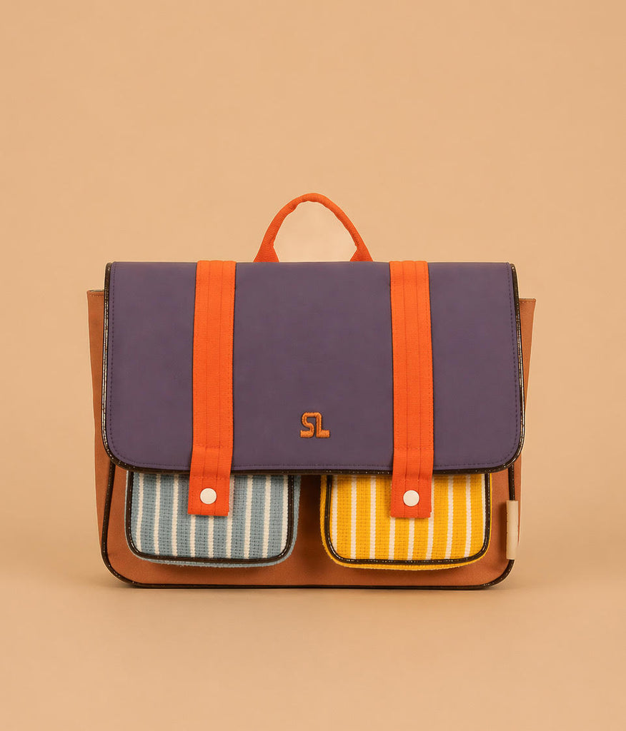 The Sticky Lemon School Bag | Better Together | Leather Ball features a purple flap, orange straps, brown sides, and two front pockets—one blue-striped, one yellow-striped—made from waterproof recycled RPET nylon and Global Recycled Standard certified.