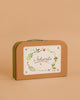 The Moulin Roty Botanist Suitcase is a small brown case with a silver handle, labeled "Le botaniste" and decorated with leafy illustrations—ideal for young botanists or storing your budding garden collection.