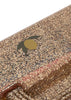 A close-up of the Konges Sloejd Creative Art Caddy - Tiger reveals a glittery, gold-speckled surface accented with a small, stylized green and yellow olive graphic, capturing the playful charm of children’s art supplies and making it a vibrant addition to any creative toolkit.