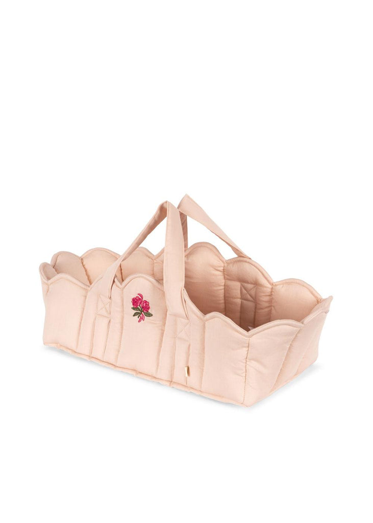 The Konges Sloejd Doll Lift - Cameo Rose is a soft, light pink quilted cotton carrycot with scalloped edges, double handles, and an embroidered rose. OEKO-TEX certified, it's perfect for little ones and their favorite dolls.