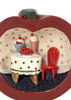 A Konges Sloejd Mini Surprise House - Cherry featuring an imaginative, miniature apple-shaped room interior with a small table, desserts, and a red chair.