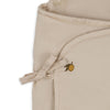 The Konges Sloejd Doll Sleeping Bag - Lemon features beige organic cotton fabric with a stitched bow and a small embroidered lemon with a leaf, offering soft padding perfect for dolls.