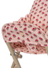 Close-up of the Konges Sloejd High Chair - Rosie Rose, featuring beige metal legs and a padded seat with a pink background, red rose floral pattern, and charming scalloped edges.