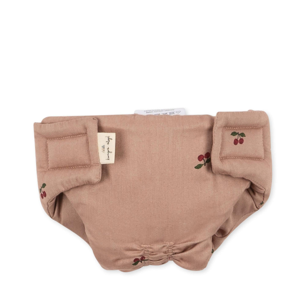 The Konges Sloejd Doll Nursery Set in Cherry Blush features a light brown diaper cover with cherry print, Velcro tabs, and a fabric brand tag on the side.