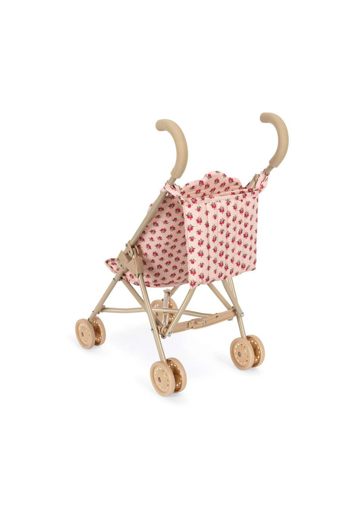 The Konges Sloejd Doll Stroller - Rosie Rose features beige handles, wheels, and a pink seat with tiny red flowers. This small toy stroller is shown against a white background.