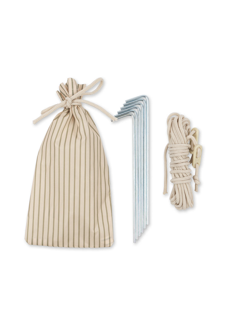 A striped beige drawstring bag, six metal tent stakes, and a coiled beige rope with a tensioner—accessories included with the Konges Sloejd Pop-Up Beach Tent UPF 50+—are displayed on a white background.