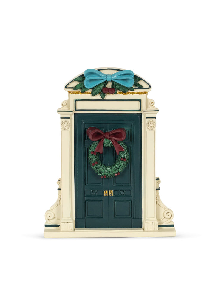 A Konges Sloejd Christmas Door in dark green, featuring a festive holiday wreath with a red bow and a blue decorative bow on top.
