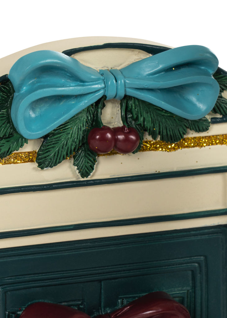 Konges Sloejd Christmas Door featuring a decorative archway topped with a blue bow, green pine needles, and red cherries, finished with a gold glitter trim.