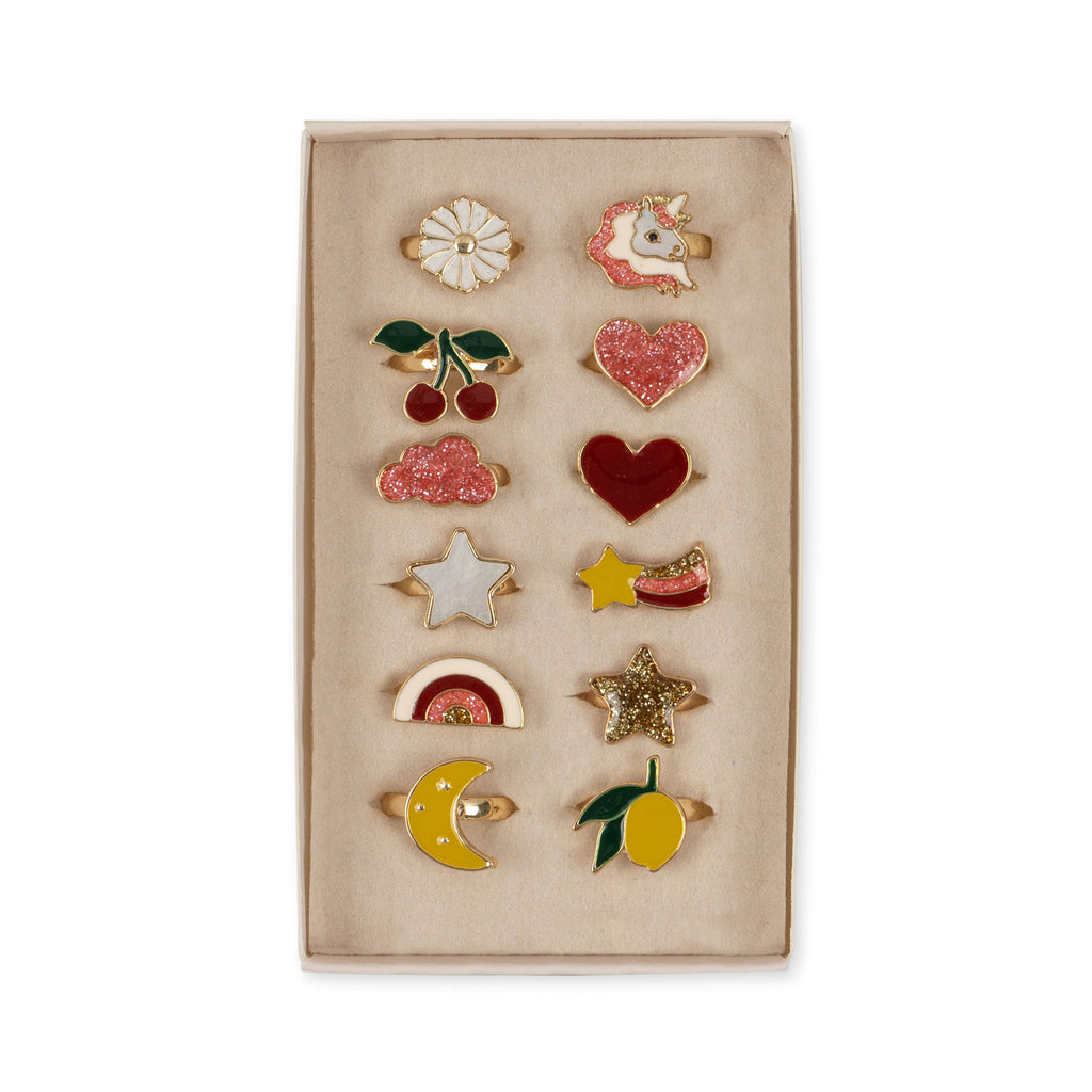 The Konges Sloejd 12 Pack Ring Set includes twelve colorful rings in a box with fun motifs like a daisy, unicorn, cherries, and heart—perfect for little ones who love playful designs.