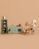 A Maileg Pastry Chef Set is paired with a Grapat Wooden Bake Set, featuring pastries, cakes, and bread displayed in a miniature kitchen scene on a plain beige background.