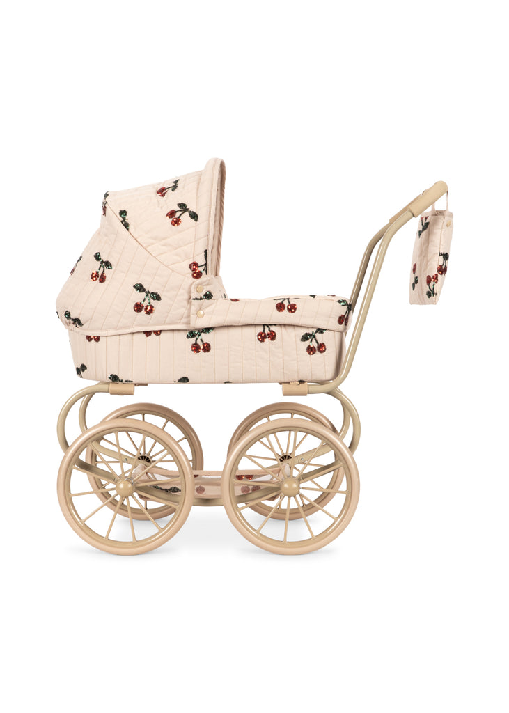 The Konges Sloejd Mini Tulle Doll Pram - Cherry Sequin features quilted beige fabric with a cherry print, light wooden wheels, a matching handle, and an attached bag—an elegant toy pram for kids to stroll their favorite dolls in style.