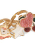 The Konges Sloejd 12 Pack Ring Set features gold-colored adjustable rings for kids, designed with playful motifs like a glittery pink heart, white star, red cherries with green leaves, and a unicorn head with pink glitter accents.