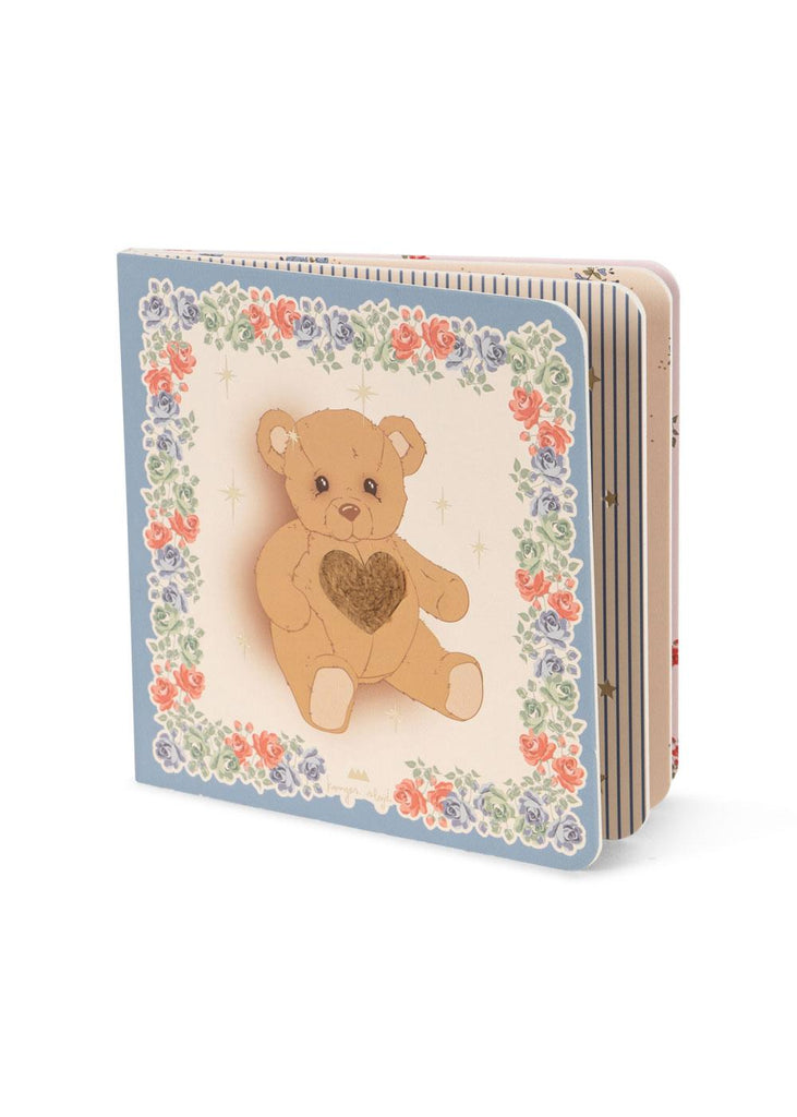 The Konges Sloejd Touch and Feel Book features a sensory cover with a brown teddy bear with a heart on its chest, framed by a floral border on blue. Perfect for little hands, this interactive book invites babies to explore different textures.