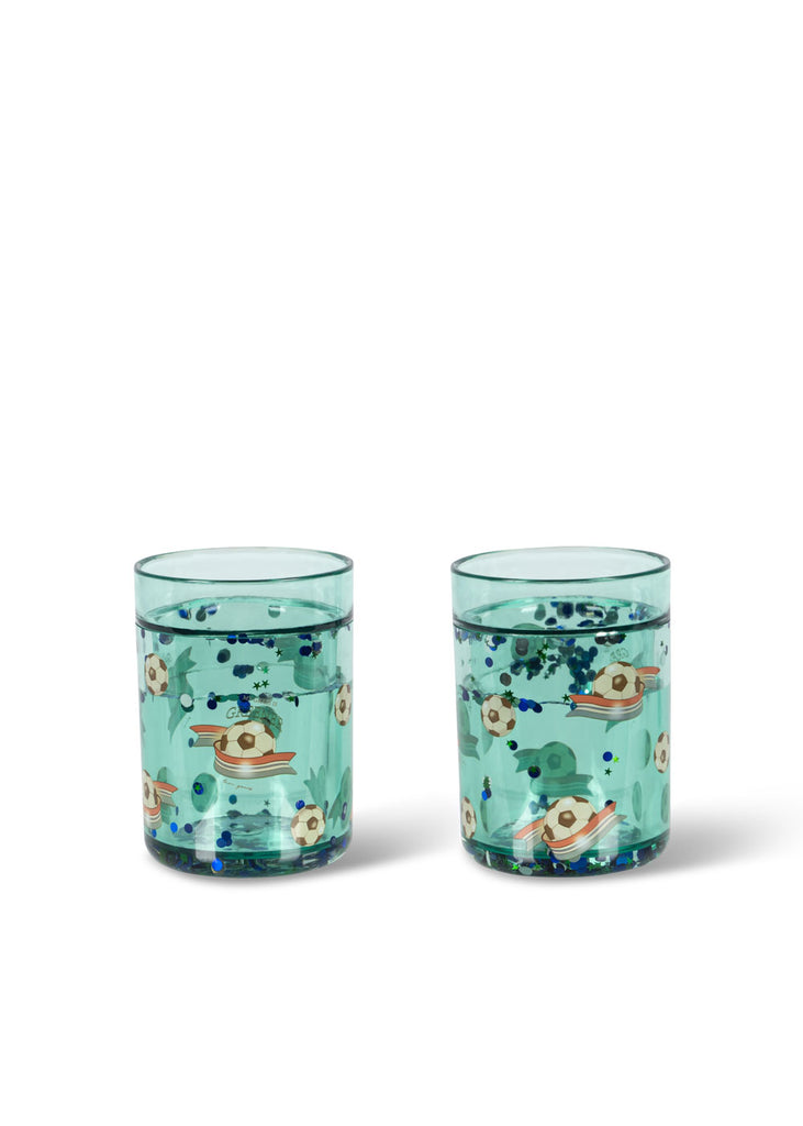 The Konges Sloejd Glitter Cup - Kick It features floating blue and silver glitter with fun designs—perfect for making kids' mealtime extra special.