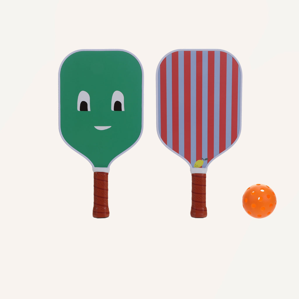 Two colorful Sticky Lemon Pick Ball Game Set bats and an orange pickleball are set against a plain background. One bat is green with a happy face, while the other has vertical red and blue stripes with a small smiley face near the bottom. Both bats have brown handles, perfectly proportioned to their playful dimensions.