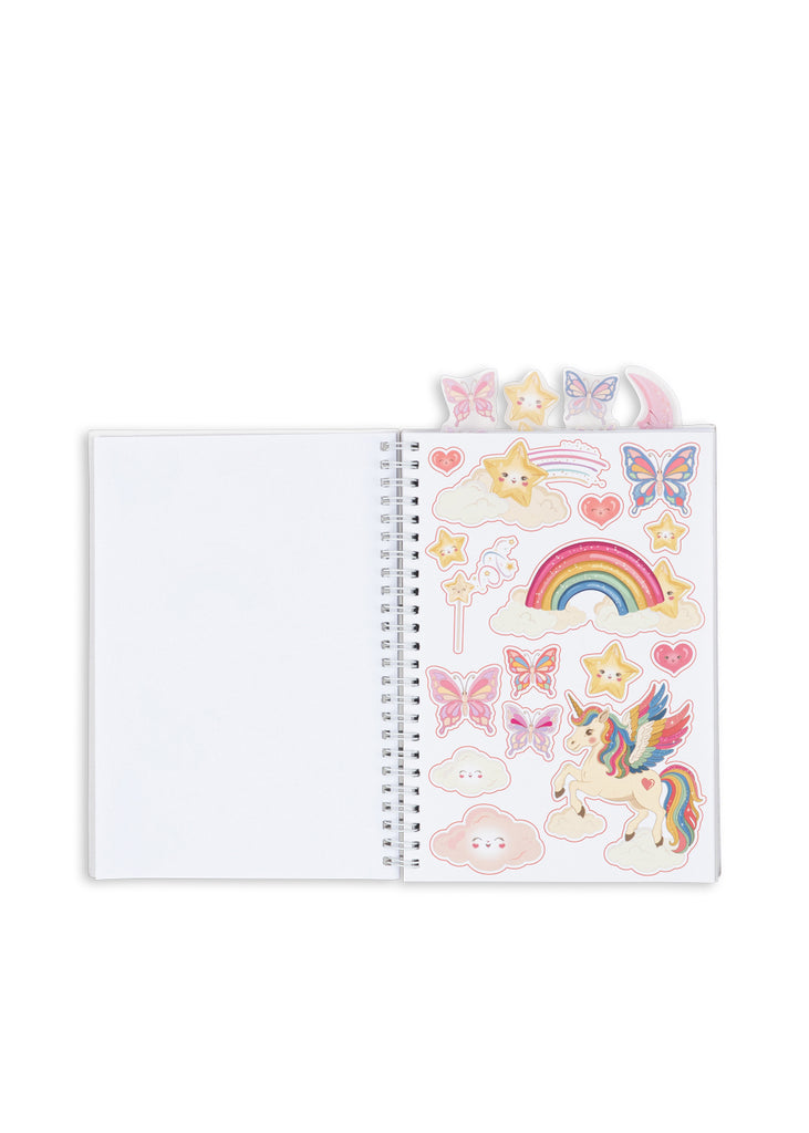 An open A5 notebook from the Konges Sloejd My Stationery Box - Unicorn, featuring a sheet of whimsical stickers with a unicorn, rainbow, butterflies, and stars.