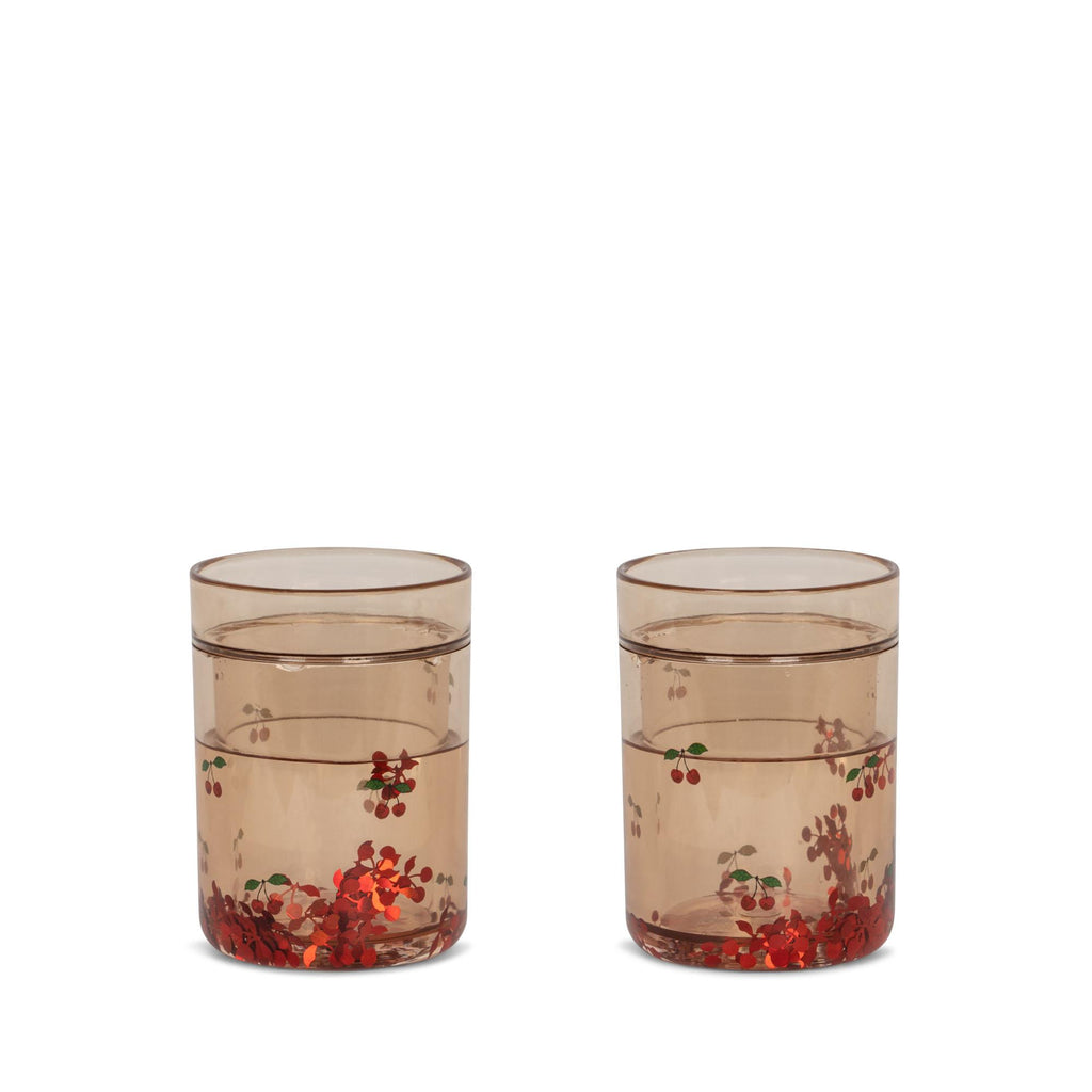 The Konges Sloejd Glitter Cups - Cherry (2 Pack) feature a light brown tint with cherry-themed floral designs, making them a charming and stylish addition to any kids drinkware collection. Perfect for fun mealtimes on a plain white background.