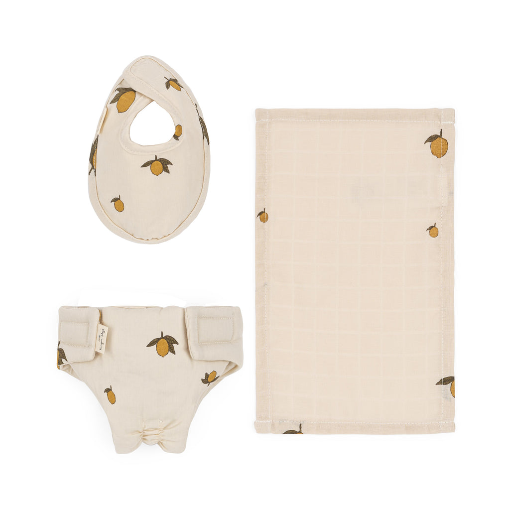 The Konges Sloejd Doll Nursery Set - Lemon includes beige organic cotton doll accessories with lemon prints: a bib, a bag, a Velcro-fastened diaper, and a rectangular burp cloth, all neatly displayed on a white background.