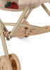 Close-up of the Konges Sloejd Doll Stroller - Strawberry, showing its sturdy plastic and metal frame, double wheels, and a strawberry patch on the removable beige fabric seat.
