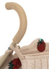 The Konges Sloejd Doll Stroller - Strawberry features a beige handle with a soft grip, removable fabric embroidered with red and green sequined strawberries, and sturdy double wheels.