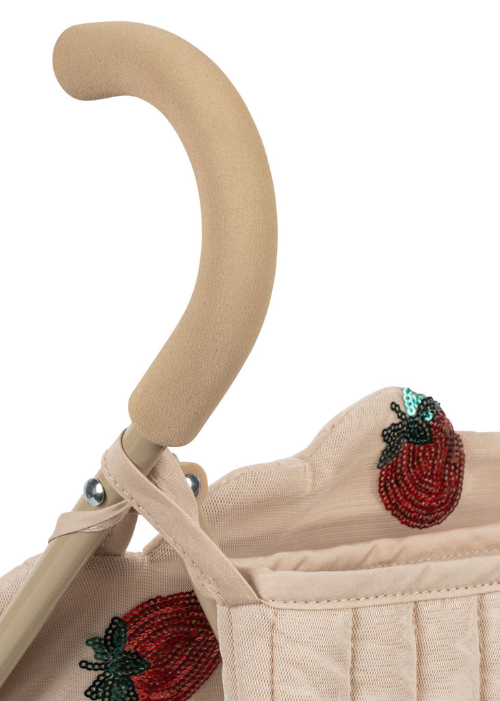 The Konges Sloejd Doll Stroller - Strawberry features a beige handle with a soft grip, removable fabric embroidered with red and green sequined strawberries, and sturdy double wheels.