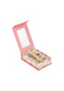 A pink, book-shaped box adorned with a floral pattern opens to reveal the Konges Sloejd 12 Pack Ring Set—an assortment of adjustable rings featuring playful decorative motifs, each displayed on a cushioned base. The inside lid features a scalloped-edged mirror, making it perfect for kids who love jewelry.