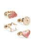 Twelve gold adjustable rings from the Konges Sloejd 12 Pack Ring Set, each with a unique decorative motif—including pink glitter clouds, white flowers, stars, and pink glitter hearts—are displayed on a white background. The adjustable bands make them perfect for little fingers.