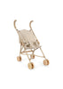 Konges Sloejd Doll Stroller - Milk Tank features a lightweight metal frame with curved handles and a fabric seat adorned with a small brown and white spotted pattern. This beige toy stroller has eight small tan double wheels for smooth movement and is shown empty.