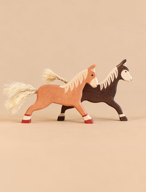 Holztiger Handmade Wooden Horses Set consisting of two handcrafted wooden horse toys, one light brown and one dark brown, featuring light-colored manes and fiber tails.