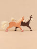 Holztiger Handmade Wooden Horses Set consisting of two handcrafted wooden horse toys, one light brown and one dark brown, featuring light-colored manes and fiber tails.