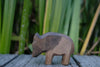 A Handmade Holzwald Wild Boar - Mother carved wooden figurine standing on a weathered wooden surface.