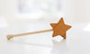 A Bannor Toys Wooden Star Wand with a star-shaped top, resting on a white surface with a blurred background.